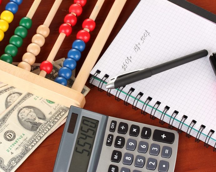 Bright wooden abacus, money bills, and calculator.