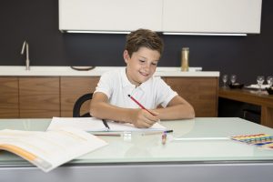 A boy happily doing his homework