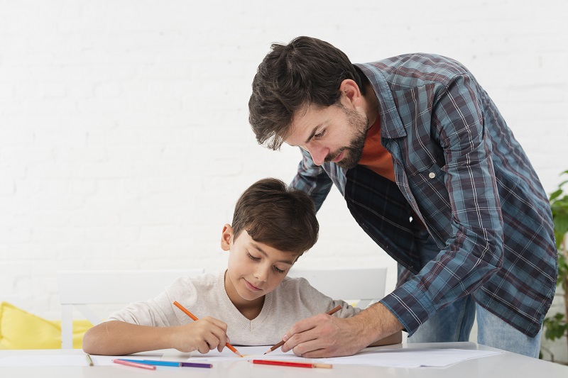 A father looking at his son's homework