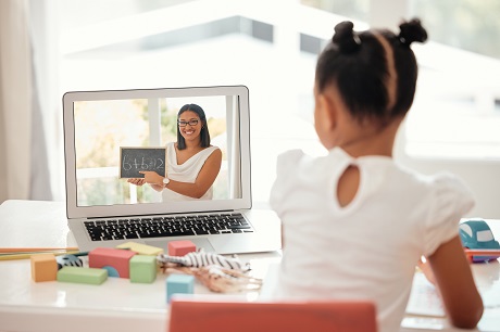 Girl, laptop and education with girl and teacher on video call, distance learning and homeschool online lesson. Learning, class and child enjoy math activity with friendly tutor at table in her home.