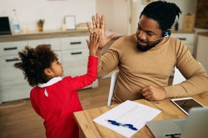 Happy African American single father giving high-five to his daughter.