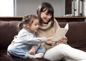 Mom and daughter spend time together reading a book. The concept of children's development and quality time.