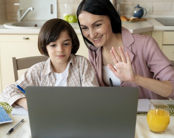 Mother helping son to do online tutoring