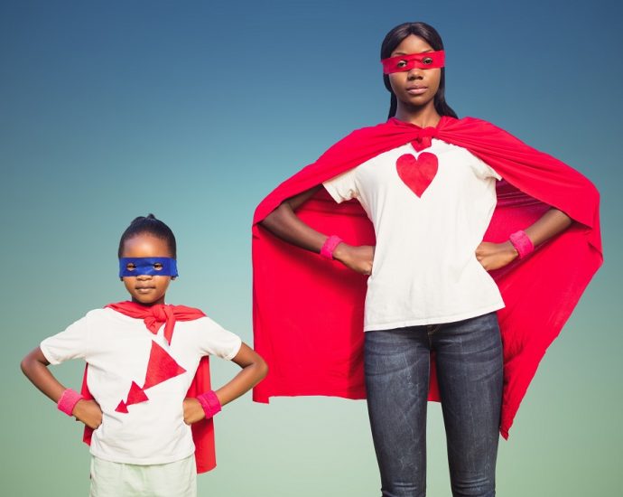 Portrait of woman and girl in superhero costumes