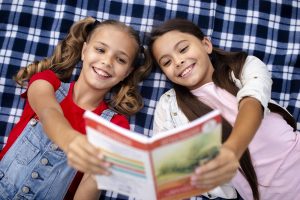 Smiling girls reading a book