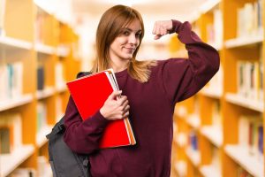 Student woman making strong gesture on unfocused background. back to school