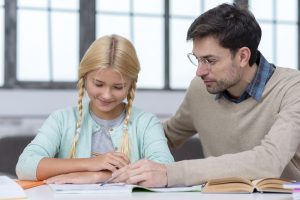 Tutor teaching young student to write