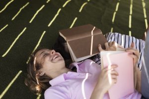 Young people lying down, reading and laughing.