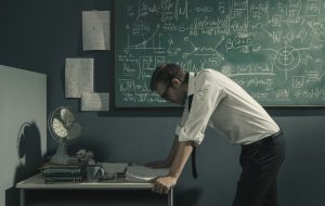 Mathematician thinking in front of blackboard