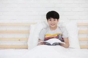 A happy Asian boy reading