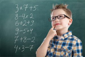 Smart Young Boy with blackboard showing algebra