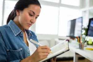 A female writing on a book