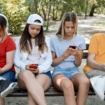 A group of teens using their phone