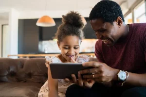 A father and a daughter enjoying a video on a phone