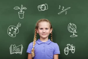 Student standing in front of a blackboard with symbols of extracurricular activities