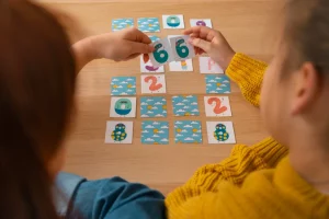 A woman and a girl playing a game using playing cards